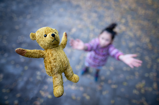 girl playing with teddy bear