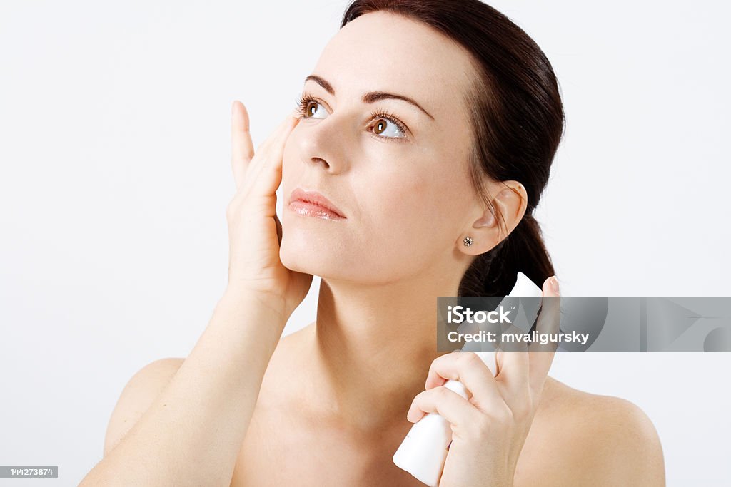 Natural beauty applying lotion Natural beauty applying lotion to her face Beauty Stock Photo