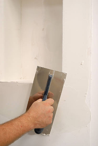 istock A trowel smoothing white parget on the wall 144274735