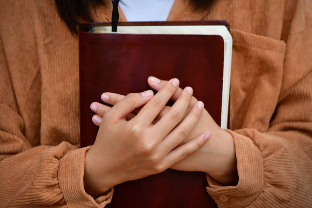 young woman hugging bible and praying to god. stock photo