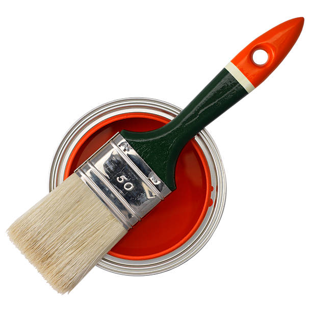 Paintbrush with red paint on a can isolated on yellow background.