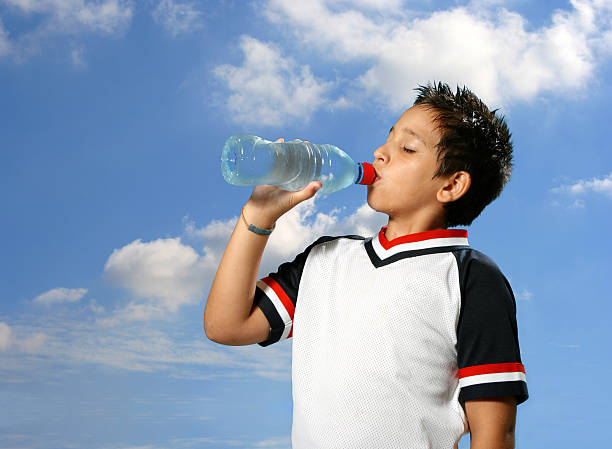 istock Thirsty boy drinking water outdoors 144275426
