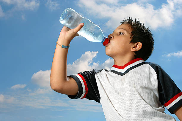 istock Thirsty boy drinking water outdoors 144275427