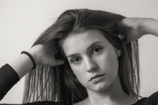 Black and white portrait of beautiful girl on the light background. Horizontally.