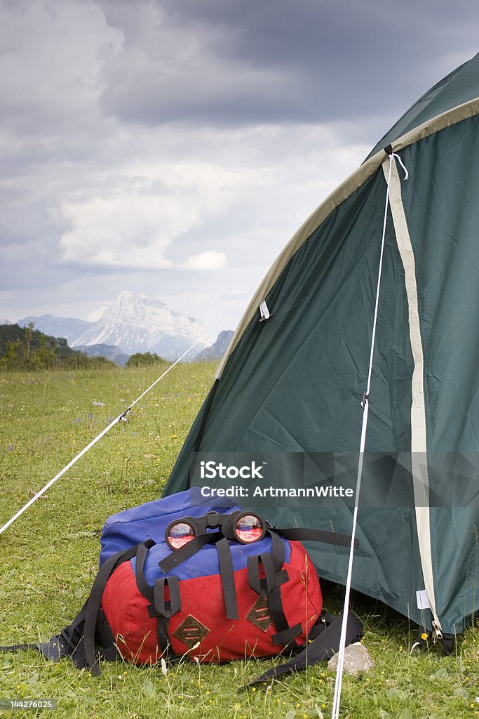 Camping in the mountains Tent, backpack and binoculars in front of a mountains scenery Activity Stock Photo