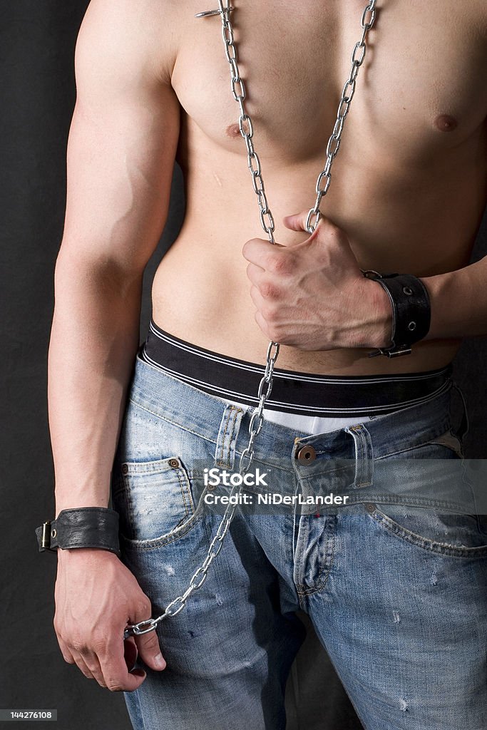 constrained man attractive male body in blue jeans and chains, freedom concept Men Stock Photo