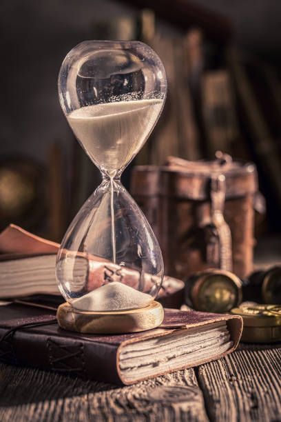 istock Aged hourglass and journal as a journey memories concept. 1442763546