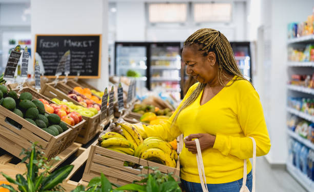 Senior African woman buying fresh fruits in supermarket stock photo