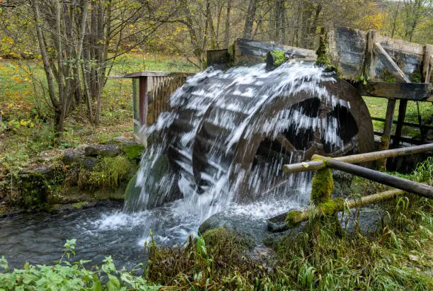 Old waterwheel set up in a stream producing energy.