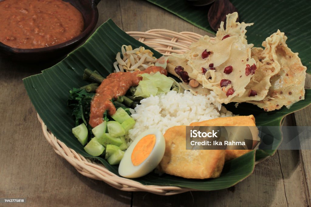 Nasi Pecel Madiun, Indonesia Food Rice and Vegetables with Peanut Sauce Nasi Pecel Madiun, Indonesia Food Rice and Vegetables with Boiled Egg and Peanut Sauce Banana Leaf Stock Photo