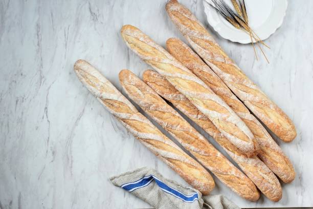 Freshly Baked French Soft Baguettes on White Marble Table. stock photo