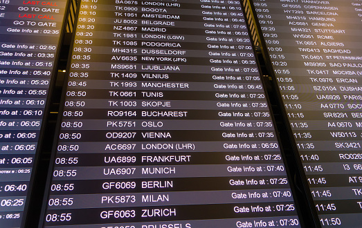 Big display in international airport. Info screen with flights and cities.