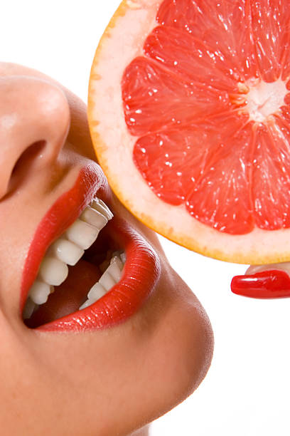 istock Beautiful young woman eating an orange 144277677