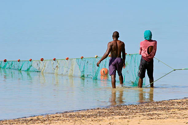 Mozambican fishermen holding fishing net stock photo