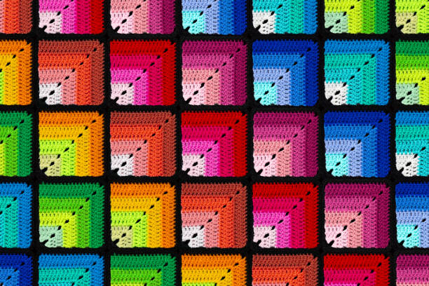 istock Bright background in the form of gradient squares is crocheted with colorful threads. Acrylic baby yarn. 1442778895