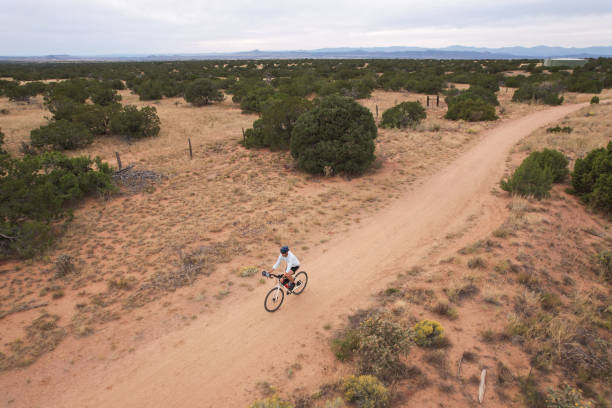 istock Solo Cyclist on a Dirt Path Surrounded by Desert Landscape in New Mexico 1442779133