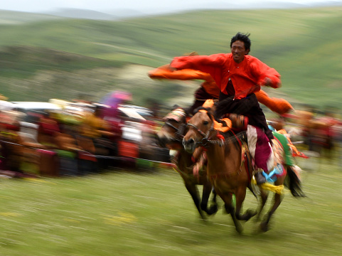 The image was shot in Tibet autonomous region on the 22nd of July in 2016.  A group of athletes were racing horses in this annual event.