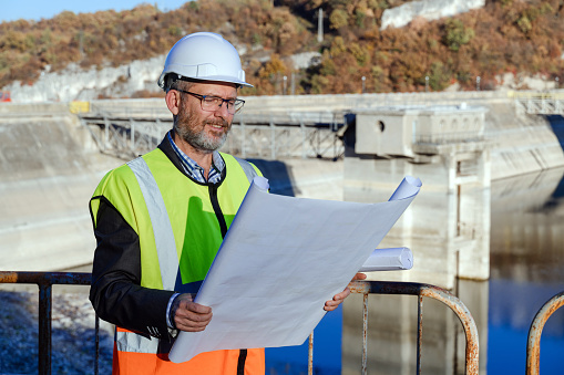 Male engineer working in hydroelectric dam. Renewable energy systems.