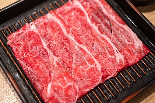 Premium quality sliced beef meat with perfect marbled textured. BBQ grill or sukiyaki meal, close-up and selective focus.