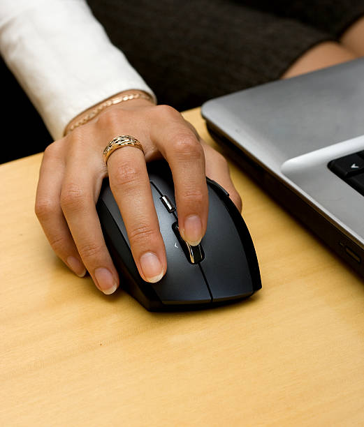 Woman's hand holding wireless mouse. stock photo