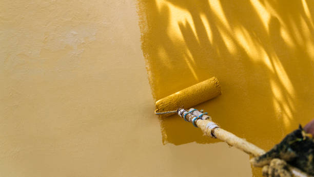 ręczne malowanie żółtej ściany wałkiem malarskim - paint brushing house painter wall zdjęcia i obrazy z banku zdjęć