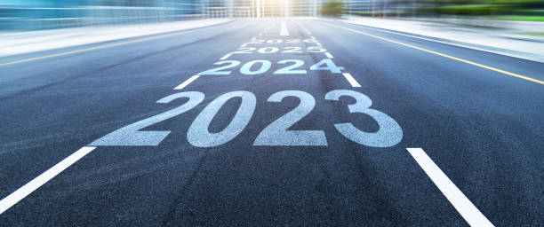 Black asphalt road with new year numbers 2023, 2024 to 2026 with white dividing lines stock photo