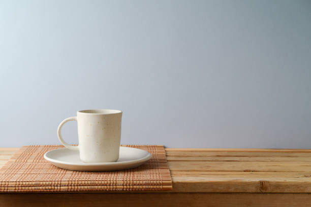 istock Coffee cup on wooden table over gray wall background.  Kitchen mock up for design and product display. 1442790335