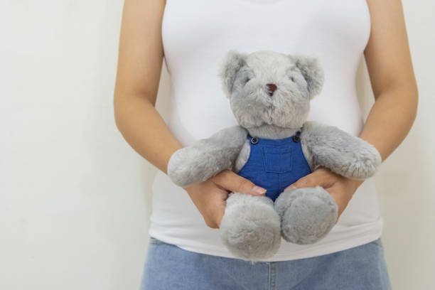 Children's hands playing with Christmas gift and teddy bear