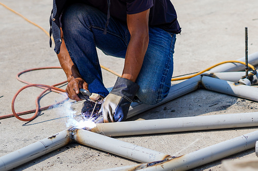 Metal worker welding roof truss