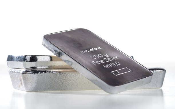 istock Minted silver bar weighing 250 grams against a background of a stack of various silver ingots. 1442795500