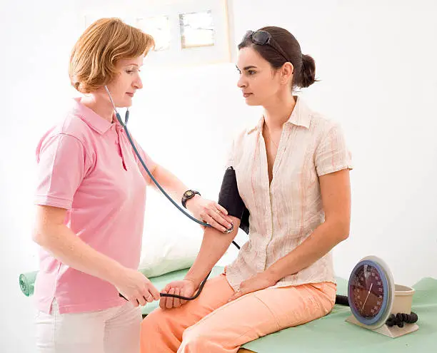Nurse measuring the patient's blood-pressure.