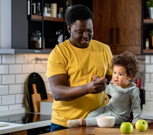 istock Father feeding a small daughter with fruit healthy food 1442803962