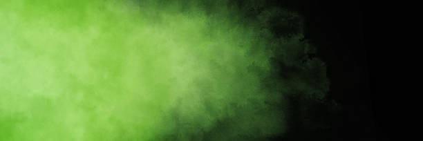 Green smoke wisps or hazy fog on black background, light green cloudy texture, elegant banner design, stormy clouds stock photo