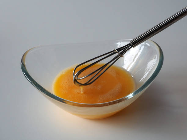 istock Raw scrambled eggs in a glass bowl with a whisk 1442806522