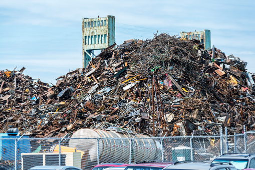 A mountain of iron, steel, aluminum and other metal scrap pieces - with items of all sizes and many possible descriptions - waiting at a recycling junk yard to be shipped and recycled for new uses.