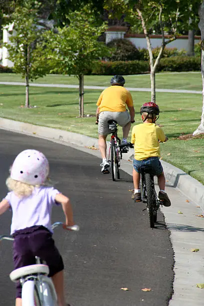 Father, son and daughter take a bike ride.