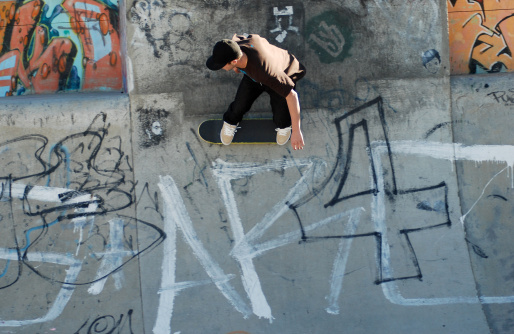 A Skate board rider riding a half-pipe with graffiti in Bondi Beach Australia