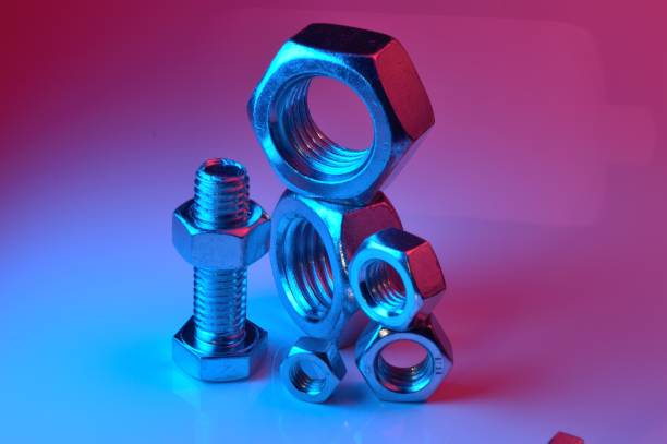istock large and small nuts and bolts, highlighted in different colors, on a light background. 1442820056