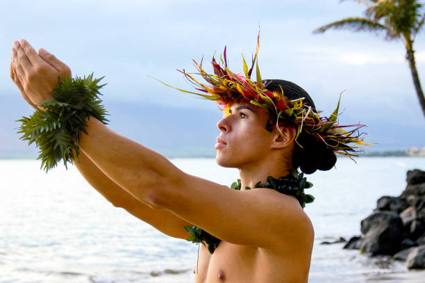 istock Male Dancer Photograph - Male Hula Dance performs on the beach with expressive hand movements. 1442822193