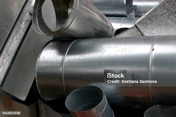 Metalic Shiny Industrial Background With Cylinder Ventilation Tubes Stacked After Dismantling Abstract Pile Of Aluminium Staff Renovation Of Ventilation System Stock Photo - Download Image Now