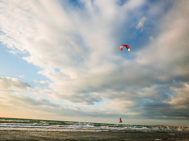 Sochi, Russia - november 19, 2022: kite- surfer jump and flying over stormy sea