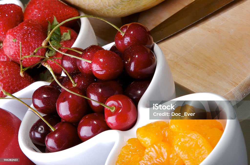 Fruit and Berries 4 Small white bowls of cherries, strawberries, and orange slices. Berry Fruit Stock Photo