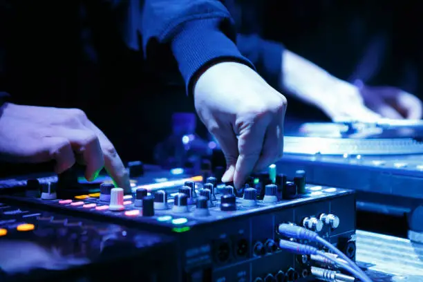 Hip hop dj mixing musical tracks with professional top level sound mixer device