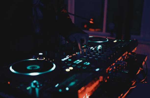 Dj plays music set on rave party in night club. Disc jockey playing musical tracks with sound mixer and turntables on concert stage. Club dj mixing musical tracks with modern cd turntables and sound mixer device club dj stock pictures, royalty-free photos & images