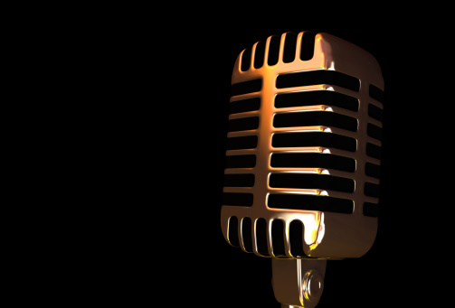 Old gold microphone on the black background