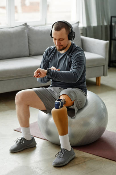 istock Man with prosthetic leg checking smartwatch during workout 1442830993