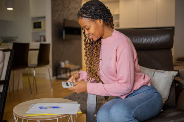 istock Young woman using calculator while going through bills and home finances 1442831535