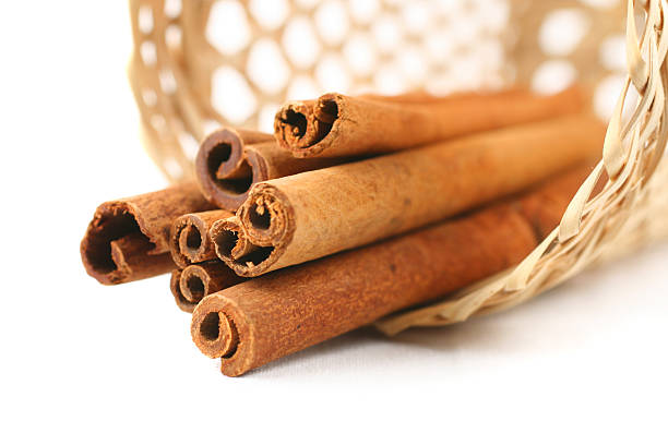 cinnamon in basket on white stock photo