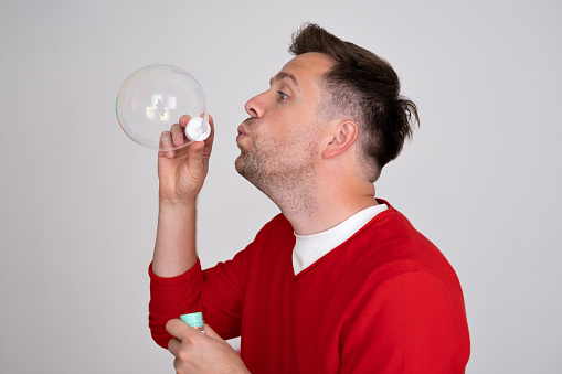 A man inflates soap bubbles. Childhood memories concept