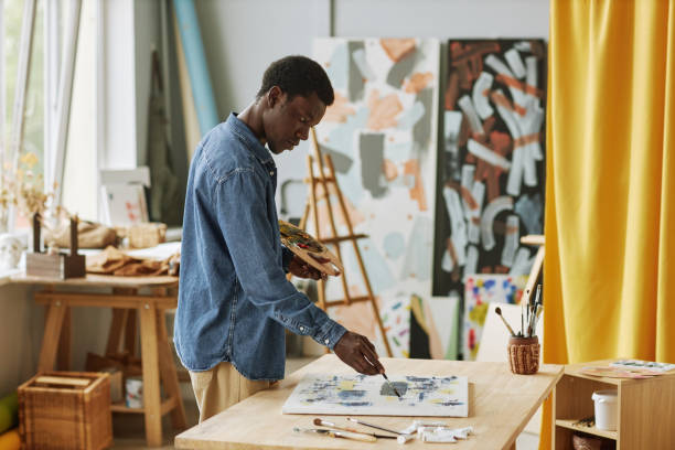 istock Young creative black man with paintbrush and color palette 1442832525